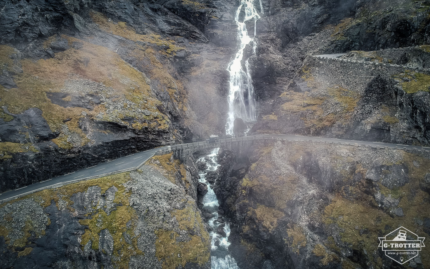 The spray of the waterfall engulfs the G on the Trollstigen.