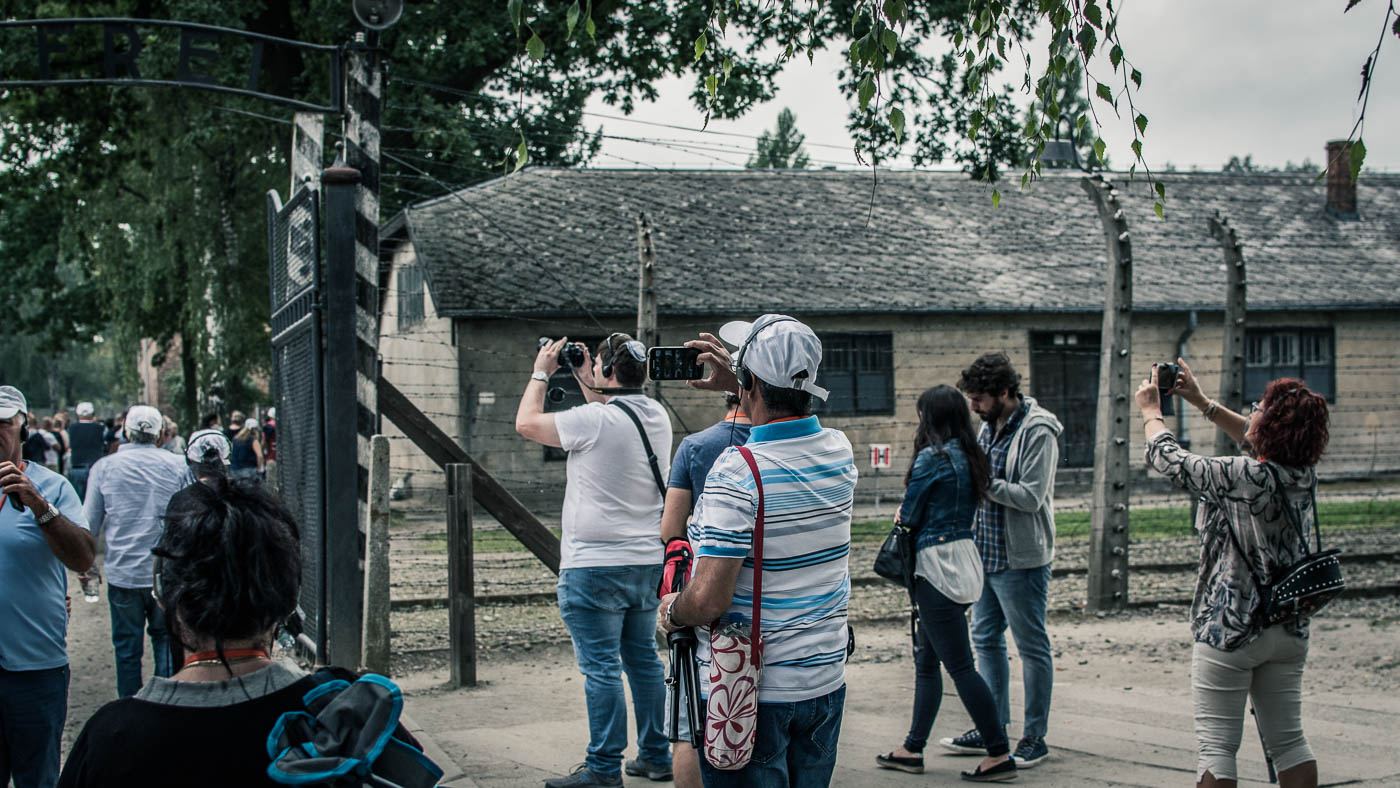 Visitors taking pictures of the gate with the phrase 