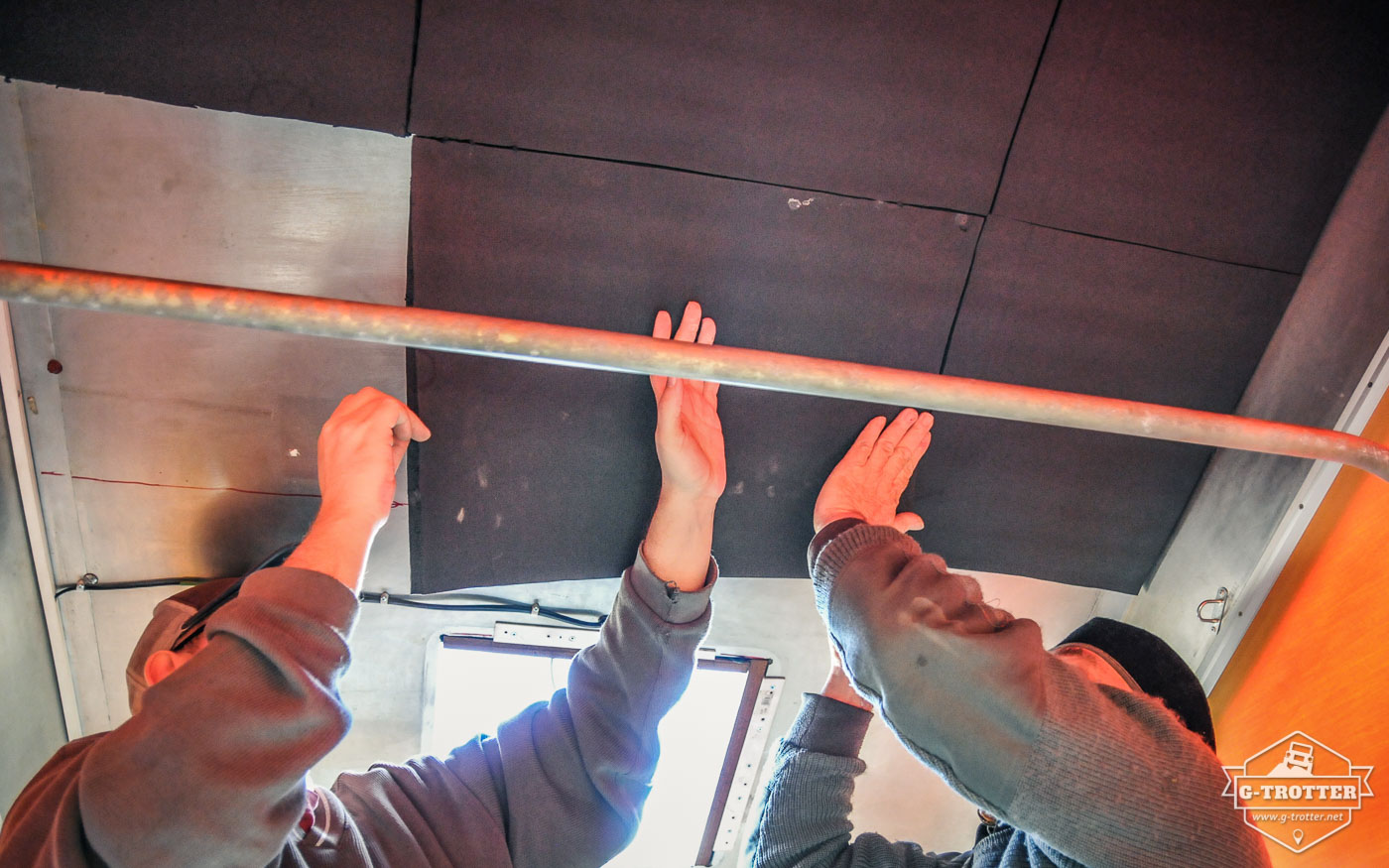 Glueing the insulation material on the inside of the roof. 